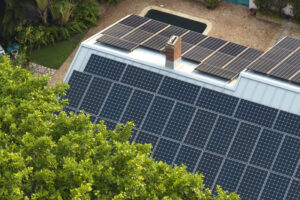 New residential house in USA with roof covered with solar panels for producing of clean ecological electricity in suburban rural area. Concept of investing in autonomous home for energy saving.